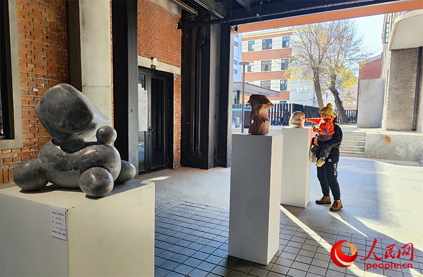 市民在天美艺术街区欣赏雕塑作品展。