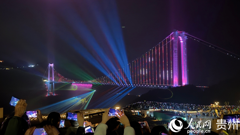 夜幕降临,大桥观景台上游客打卡拍照。