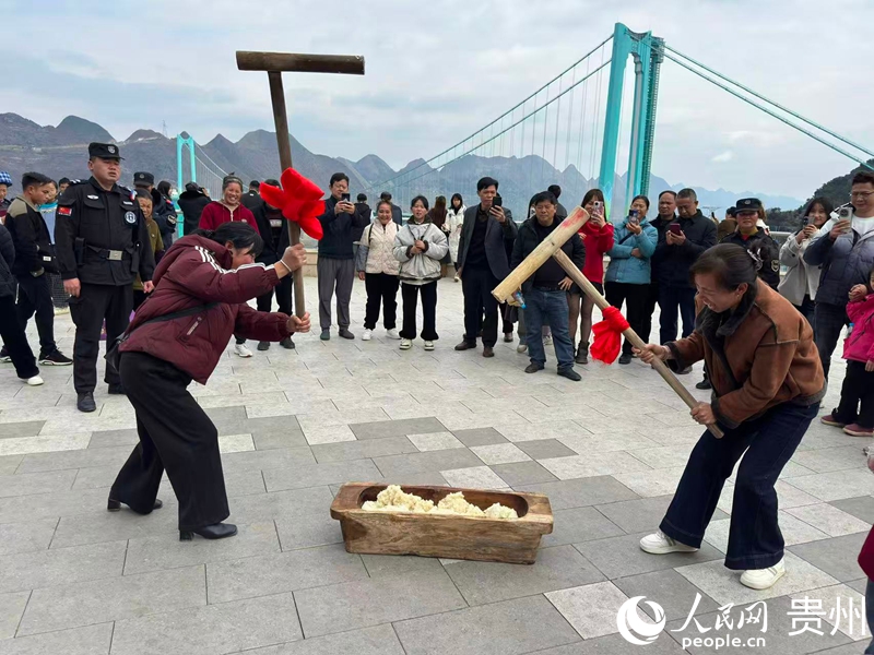 游客以大桥为背景参与打糍粑。