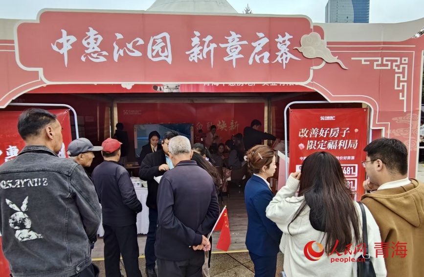 市民在房企展位前咨询。