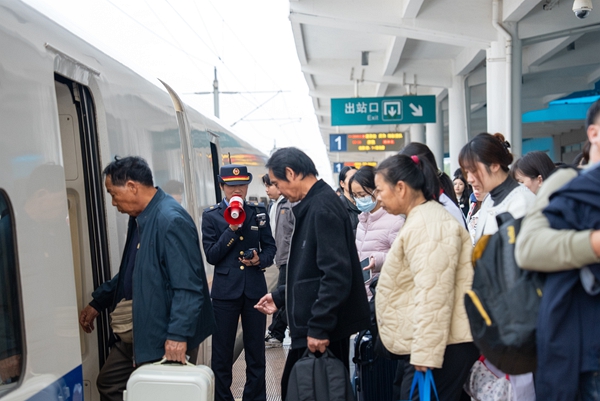 工作人员提醒旅客注意登乘安全。何家海摄